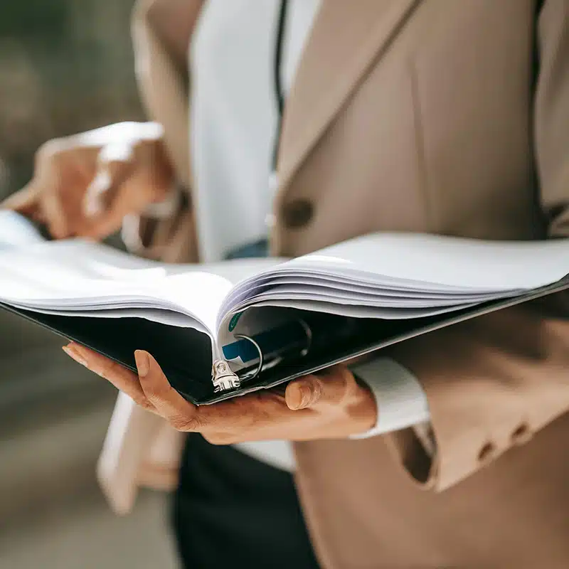 Ausschnitt einer Dame mit Mappe in der Hand
