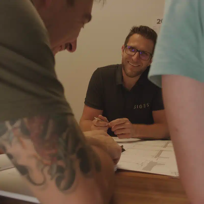 Personen die vor einem Plan sitzen und lachen