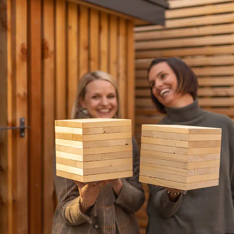 Zwei Personen die den Wandaufbau in der Hand halten.